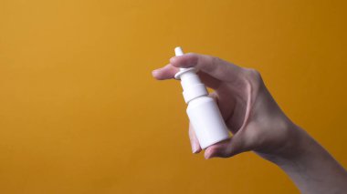Kadın eli burun spreyi tutuyor.