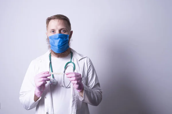 bearded doctor with a thermometer in his hands