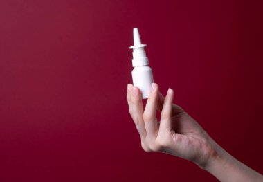 Kadın eli burun spreyi tutuyor.