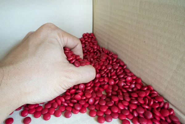 Birçok kırmızı vitamin tabletleri elle tutuluyordu..