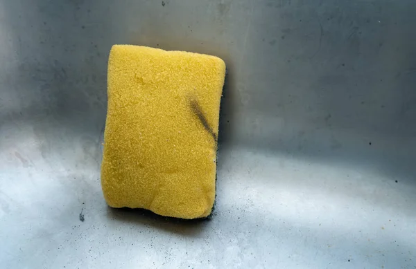 Eski bir bulaşık süngeri sarı, ince desenli ve yeşil desenli görünür..