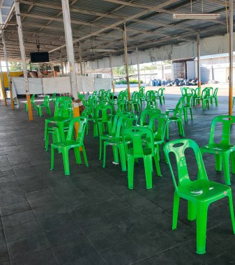 Parlak yeşil plastik sandalyeler, dağınık ve dağınık, insanların oturup beklemesi için çabucak hazırlan..