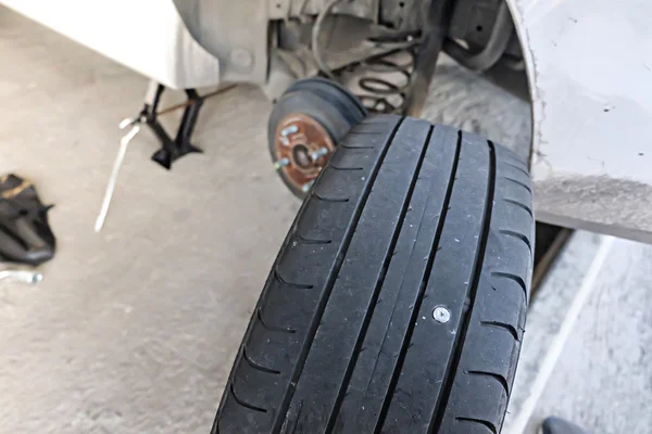 Close up de parafuso prego perfuração pneu do carro — Fotografia de Stock