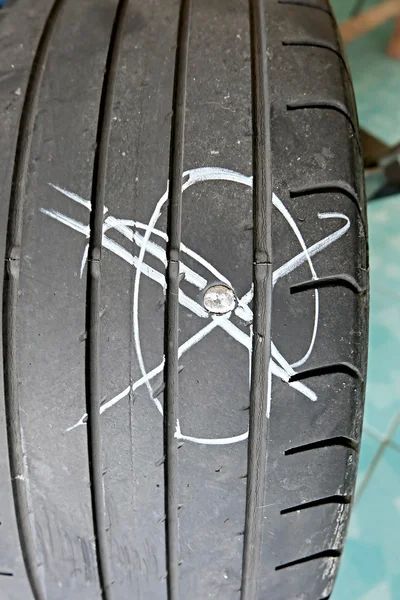 Close up of screw nail puncturing car tire — Stock Photo, Image