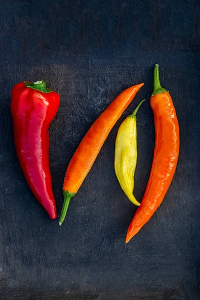 Sonbaharda, siyah bir tabakta renkli acı biber topladım.