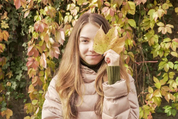 Młoda Modelka Trzymająca Żółty Liść Pobliżu Twarzy Jesiennym Parku Portret — Zdjęcie stockowe