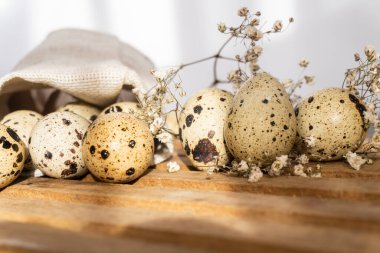 Çuval bezi üzerinde taze bıldırcın yumurtaları, ahşap masa, seçici odak
