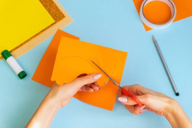 Paskalya kartları kağıttan. Mavi arka planda tavşanlı cildi selamlama kartları. Üç boyutlu. Hediye fikri, dekor ilkbaharı, Paskalya. Adım adım. Üst Manzara. Süreç çocuk zanaatı.