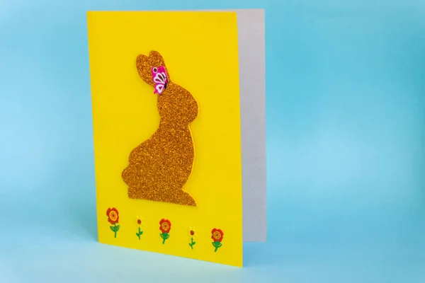 Diy Easter cards from paper. Volume greeting cards with a bunny, on blue background. 3d. Gift idea, decor Spring, Easter. Step by step. Top view. Process kid children craft. Colorful holiday decoration, the final result