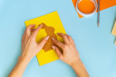 Paskalya kartları kağıttan. Mavi arka planda tavşanlı cildi selamlama kartları. Üç boyutlu. Hediye fikri, dekor ilkbaharı, Paskalya. Adım adım. Üst Manzara. Süreç çocuk zanaatı.