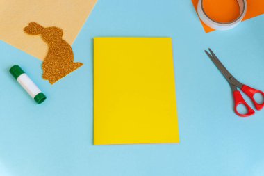 Paskalya tavşanı, çocuklar için kolay zanaatlar, renkli kâğıttan tebrik kartlarıyla bembeyaz yatıyordu. Adım adım. Bahar, Paskalya. Konsept: Paskalya için çocuk el işi. Basamaklardaki talimatlar.