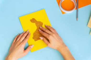 Paskalya tavşanı. Tebrik kartı. Tatil süslemeleri. Konsept: Paskalya için çocuk el işi. Basamaklardaki talimatlar.