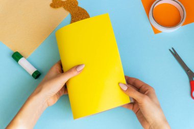 Paskalya tavşanı, çocuklar için kolay zanaatlar, renkli kâğıttan tebrik kartlarıyla bembeyaz yatıyordu. Adım adım. Bahar, Paskalya. Konsept: Paskalya için çocuk el işi. Basamaklardaki talimatlar.