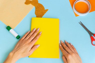 Paskalya kartları kağıttan. Mavi arka planda tavşanlı cildi selamlama kartları. Üç boyutlu. Hediye fikri, dekor ilkbaharı, Paskalya. Adım adım. Üst Manzara. İşlemci çocuk işi. Renkli tatil dekorasyonu