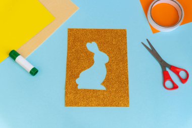 Paskalya kartları kağıttan. Mavi arka planda tavşanlı cildi selamlama kartları. Üç boyutlu. Hediye fikri, dekor ilkbaharı, Paskalya. Adım adım. Üst Manzara. İşlemci çocuk işi. Renkli tatil dekorasyonu