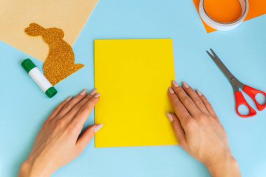 Paskalya tavşanı. Tebrik kartı. Tatil süslemeleri. Konsept: Paskalya için çocuk el işi. Basamaklardaki talimatlar.