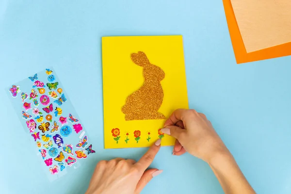 Diy Easter cards from paper. Volume greeting cards with a bunny, on blue background. 3d. Gift idea, decor Spring, Easter. Step by step. Top view. Process kid children craft.