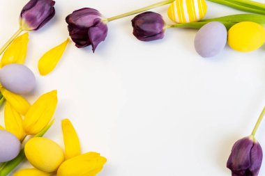 Düz paskalya kompozisyonu, laleler ve yumurtalar. Mutlu Paskalya tebrik kartları. Kopyalama alanı olan üst görünüm.