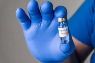 Coronavirus aşısı COVID-19 'un geliştirilmesi ve yaratılması. Coronavirus aşısı kavramı doktor mavi aşı kavanozunun elinde. Aşı Coronavirus 'a karşı savaş kavramı.