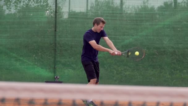 Теннисист играет в теннис — стоковое видео