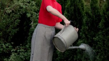 Saçına saç Curlers giyen güzel genç kadın selvi açık havada sular