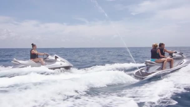 Flickvänner ridning på vattenskoter i havet — Stockvideo