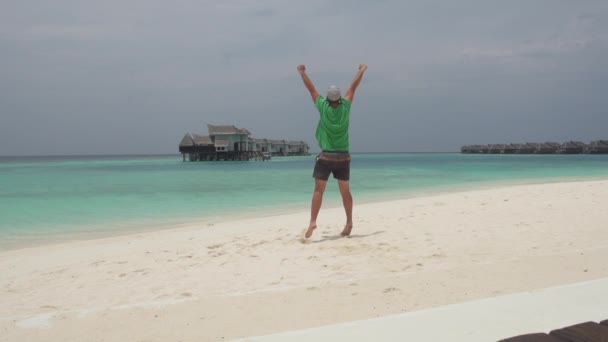 Homem saltando com alegria na praia — Vídeo de Stock