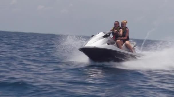 Vriendinnen paardrijden op jet ski's in de zee — Stockvideo