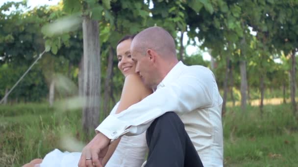 Hochzeitspaar sitzt in der Natur — Stockvideo