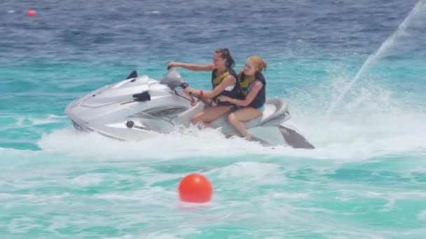 Vriendinnen paardrijden op jet ski's in de zee — Stockvideo