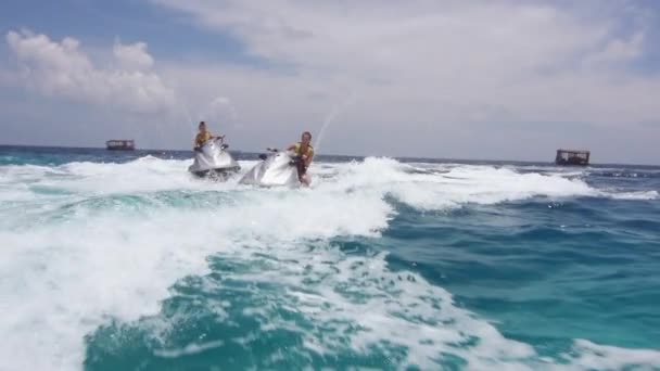 Vriendinnen paardrijden op jet ski's in de zee — Stockvideo