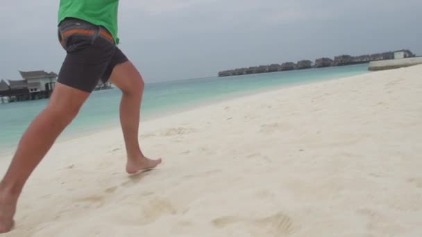 Hombre corriendo por la playa de arena — Vídeo de stock