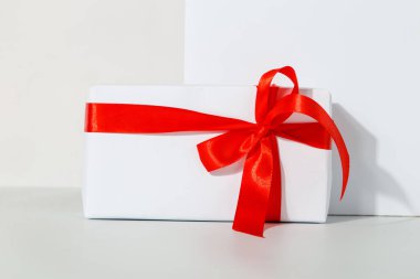 Beyaz arka planda kırmızı kurdeleli bir hediye, bayram konsepti, tebrikler..