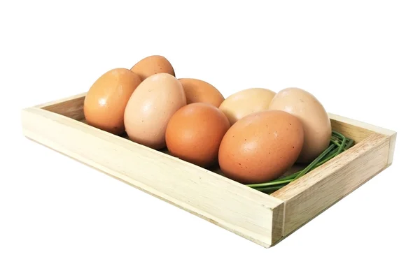 Huevos en caja de madera y hierba sobre fondo blanco —  Fotos de Stock