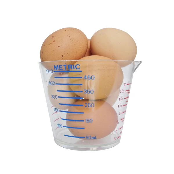 鸡蛋在白色背景上量杯 — 图库照片
