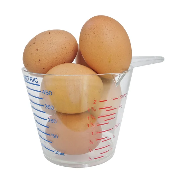Huevos en taza medidora sobre fondo blanco —  Fotos de Stock
