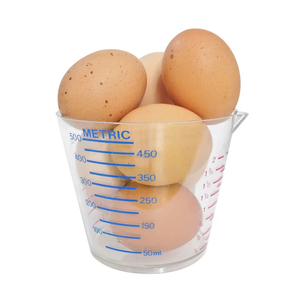 Eggs in measuring cup on white background — Stock Photo, Image