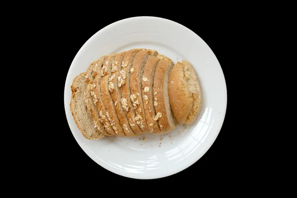 Gebakken brood op een witte plaat, zwarte achtergrond geïsoleerd — Stockfoto