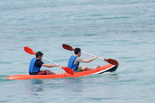 Giovane uomo kayak giù un mare Immagini Stock Royalty Free