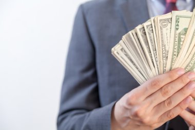 Banka notları ile beyaz izole arka planda tutan işadamı