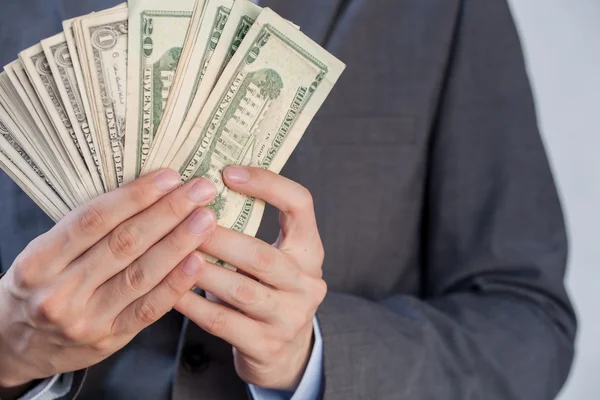 Podnikatel, držící bankovky v bílém pozadí izolované, s — Stock fotografie