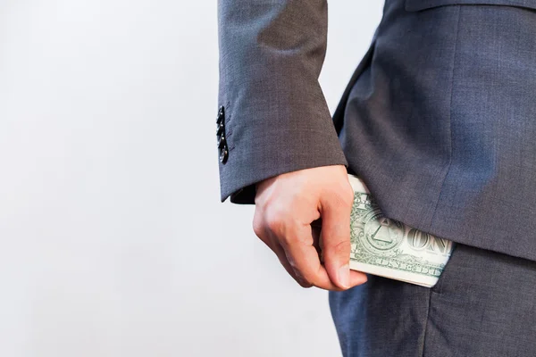 Mano de hombre de negocios escondiendo dinero en el bolsillo — Foto de Stock