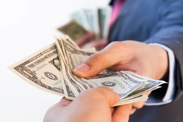 Hombre de negocios dando billetes de banco a otra persona . — Foto de Stock