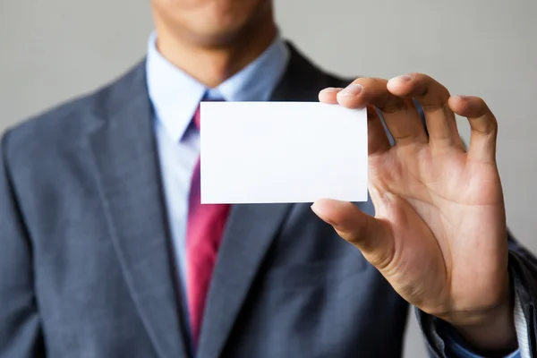 Joven en traje de negocios con tarjeta blanca en blanco . —  Fotos de Stock