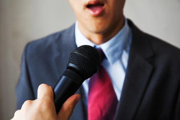 Young man feeling awkward getting asked by a journalist — Stock Photo, Image