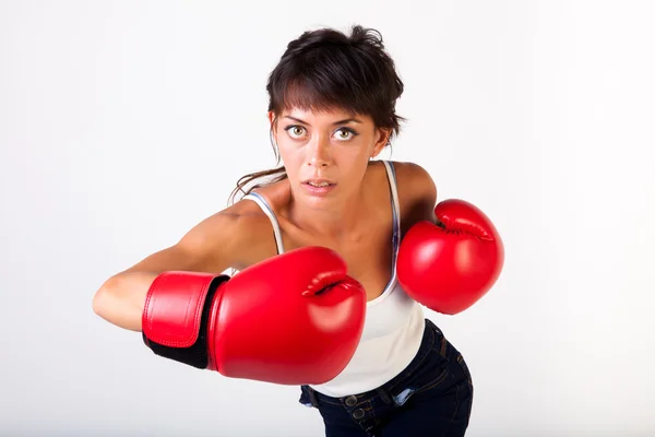Joven hermosa mujer golpeando mientras usa guantes de boxeo sobre fondo blanco aislado - fitness y concepto de poder — Foto de Stock