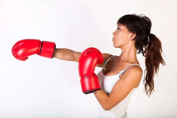 Joven hermosa mujer golpeando mientras usa guantes de boxeo sobre fondo blanco aislado - fitness y concepto de poder — Foto de Stock