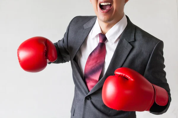 Homme d'affaires en gants de boxe lançant un punch isolé sur fond blanc — Photo