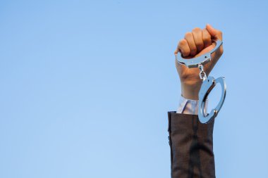 Business man showing handcuffs after releasing it. clipart