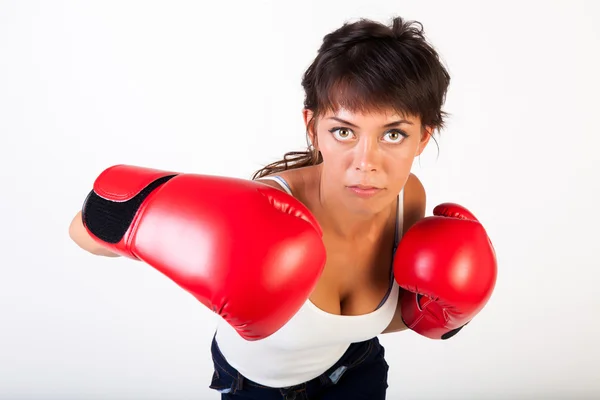 Mujer hermosa joven golpeando hacia la cámara con guantes de boxeo sobre fondo blanco aislado - fitness y concepto de poder — Foto de Stock